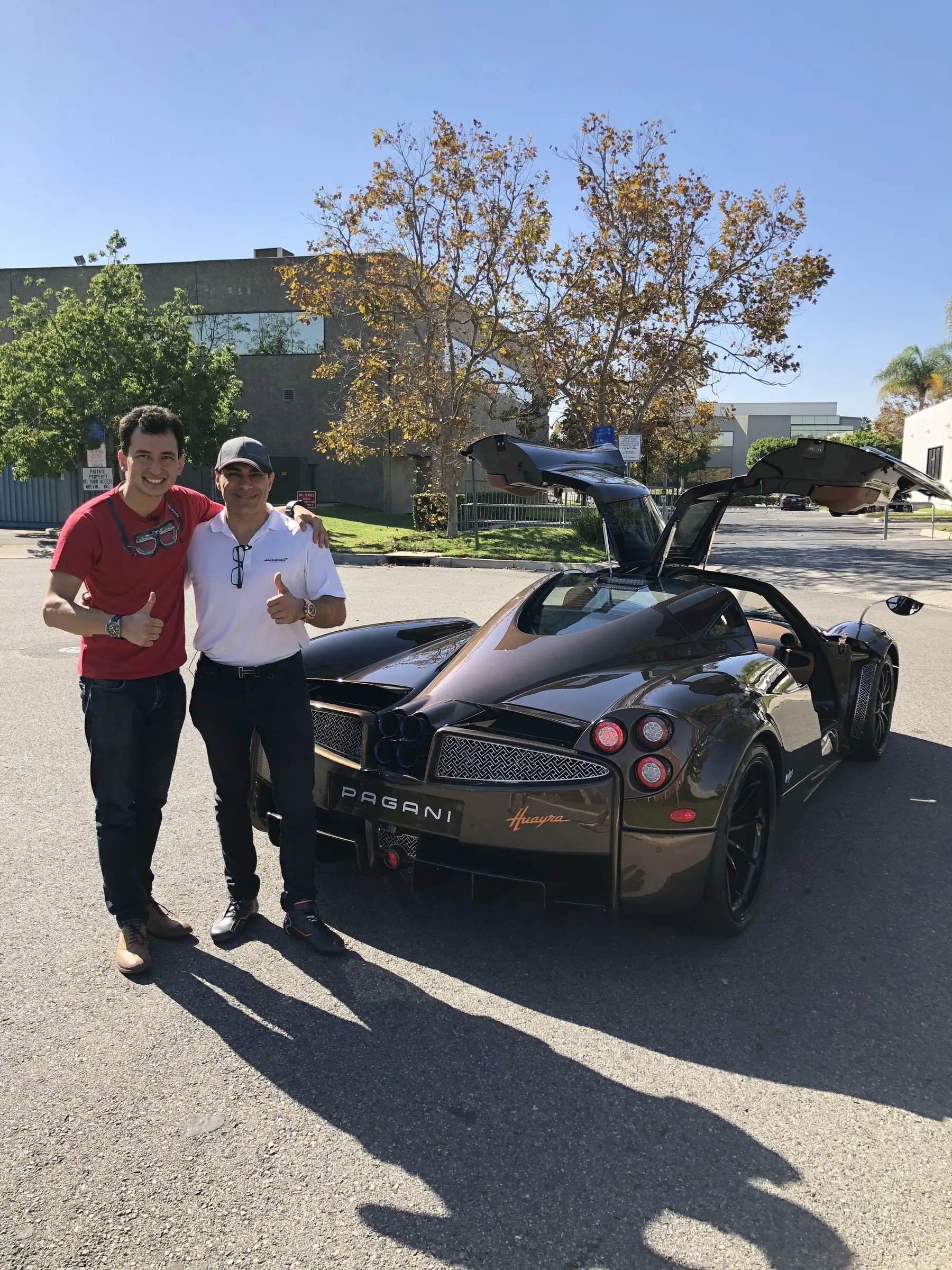 Alan with two collectors beside a hypercar with gullwing doors